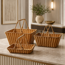 Small, medium, and large woven picnic baskets with handles on a console