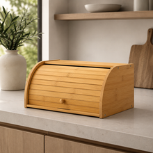 Bamboo bread box with roll-top door displayed beside cutting boards