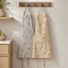 Mist gray and warm beige floral aprons hanging in a kitchen