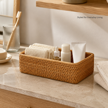 Rattan storage basket holding toiletries on a bathroom counter